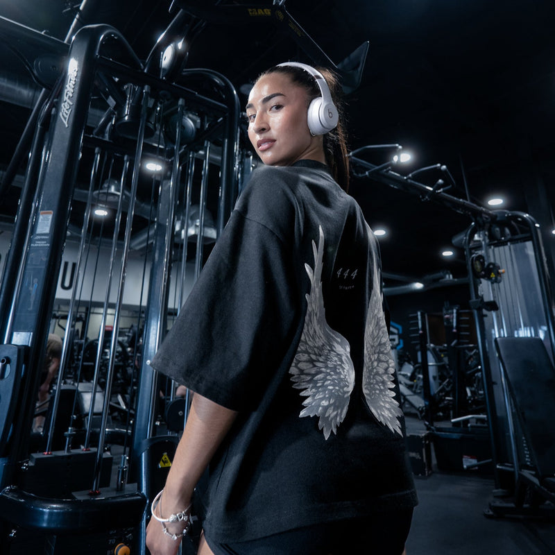 A fitness model wearing the "444 Angel Wings" tee in a gym setting